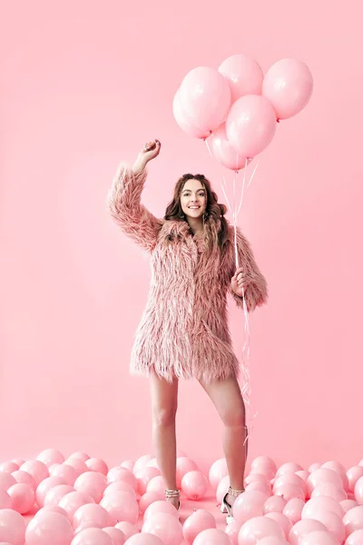 Портрет щасливої гламурної жінки з рожевими кульками на рожевому пастельному фоні — стокове фото