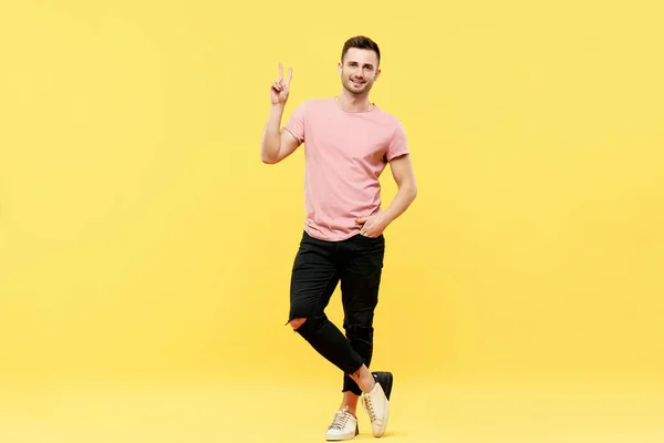 Retrato de comprimento total da moda homem bonito mostrar sinal de vitória no fundo amarelo — Fotografia de Stock