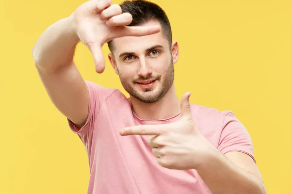 Ortrait de homem bonito sorrindo fazendo quadro com os dedos e olhando para a câmera — Fotografia de Stock