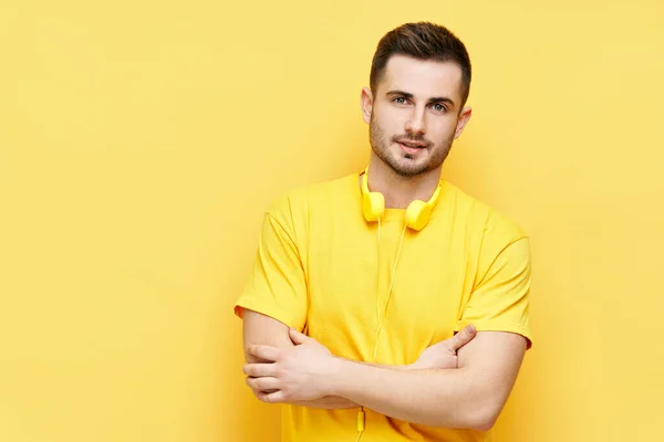 Moda homem bonito com braços cruzados e fones de ouvido olhando para a câmera — Fotografia de Stock