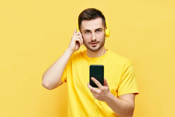 Hombre caucásico guapo escuchando música desde su teléfono y auriculares —  Fotos de Stock