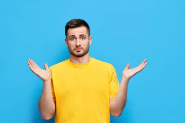 Kafası karışmış genç adam ellerini yana açıyor seçim yaparken şüpheye düşüyor.