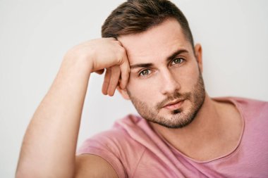 Beyaz arka planda kameraya bakan yakışıklı seksi adamın yakın plan portresi.