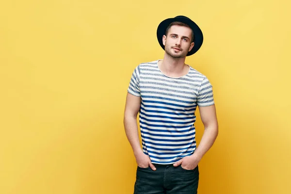 Retrato de moda de jovem hipster homem em chapéu sobre fundo amarelo — Fotografia de Stock