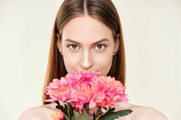 Portrait of beautiful young woman with flowers on studio background — Stok fotoğraf