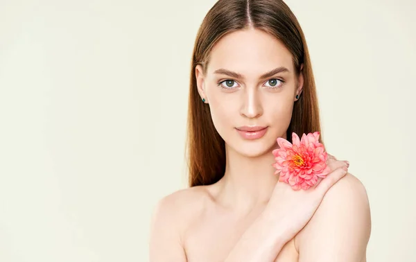 Close-up portret van mooie jonge vrouw holding bloem op studio achtergrond — Stockfoto