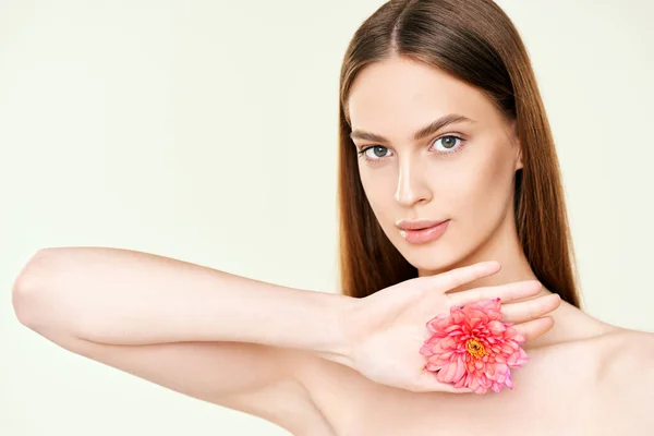 Close up portrait of beautiful young woman with flower on studio background — Stok fotoğraf