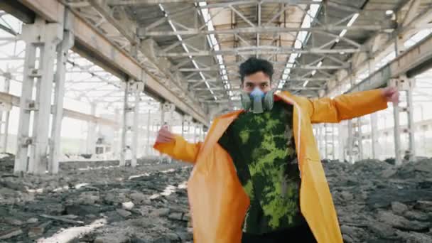 Fiatal férfi táncos védő maszkban különböző freestyle táncot jár romos elhagyatott épületben — Stock videók