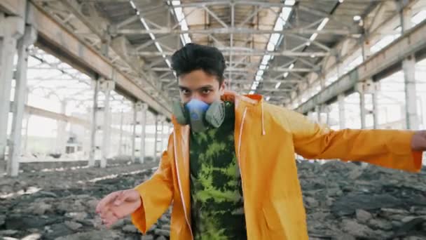 Mladý muž tanečník v ochranné masce provádění různých freestyle tanec v zničené opuštěné budově — Stock video