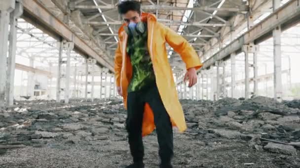 Młody mężczyzna tancerz w masce ochronnej taniec w zrujnowany opuszczony budynek — Wideo stockowe