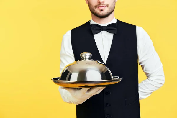 Giovane bel cameriere che tiene in mano vassoio di metallo con coperchio pronto da servire — Foto Stock