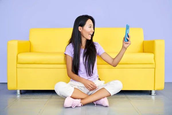 Glimlachende aziatische vrouw het maken van video bellen door mobiele telefoon praten met vrienden of familie — Stockfoto