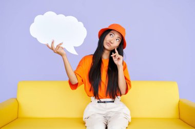 Düşünceli hippi kadın elinde boş bir konuşma balonuyla yukarı bakıyor.