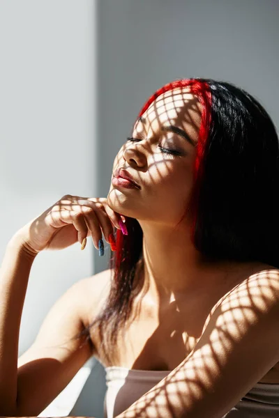 Portrait of pretty african american woman with closed eyes and shadows on her face — Stock Photo, Image