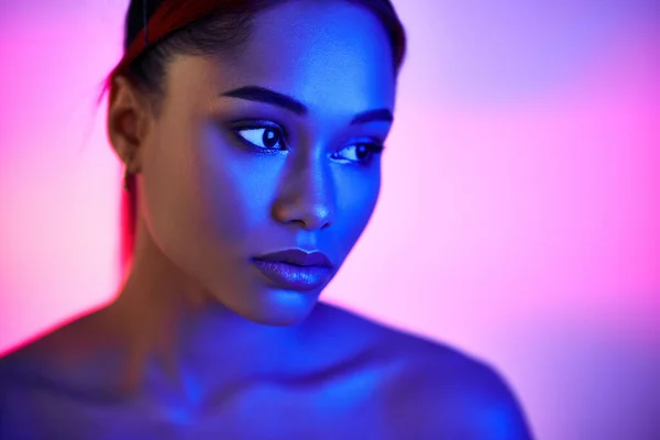 Closeup portrait of pretty african american woman in bright neon lights — Stock Photo, Image