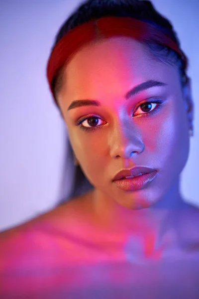 Closeup portrait of pretty african american woman in bright neon lights — Stock Photo, Image