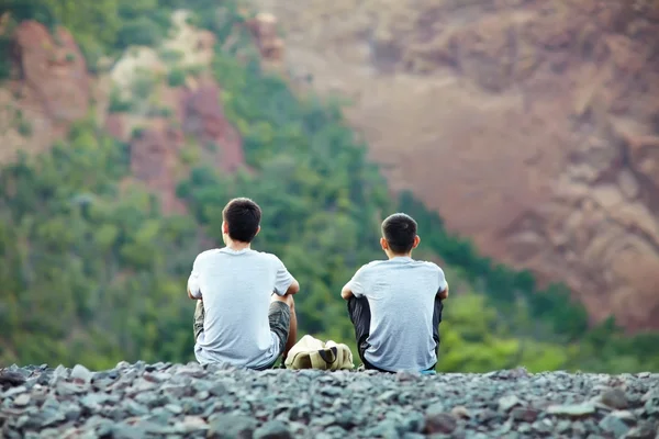 Два чоловіки сидять на скелі — стокове фото