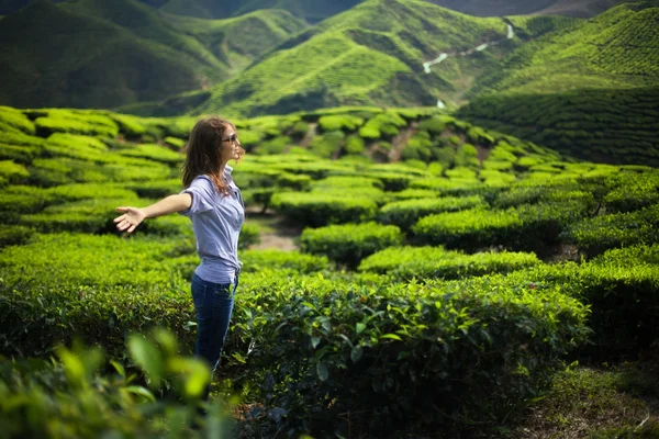 Frau mit offenen Armen auf Teeplantage — Stockfoto