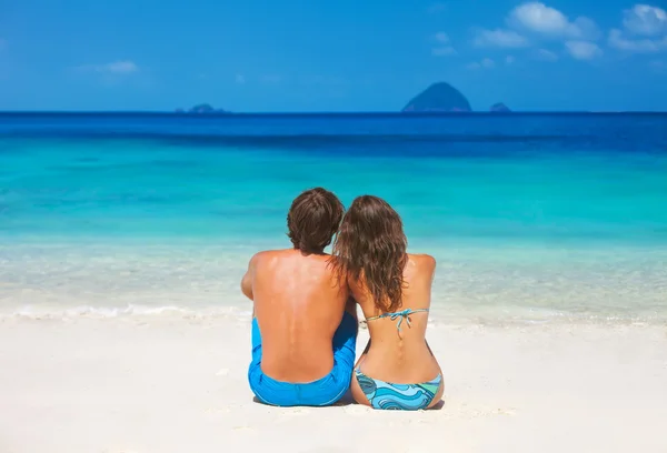 Paar ontspannen op het strand Stockafbeelding