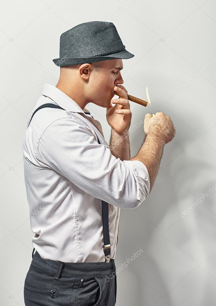 Handsome young man smoking cigar
