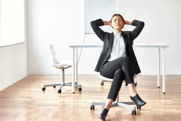 Деловая женщина сидит на стуле в офисе — стоковое фото