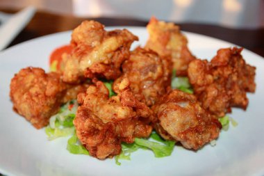 Marul yapraklarından bir yatakta kızarmış tavuk dilimleri.