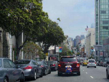 San Francisco, California - Temmuz 2018: San Francisco 'da kaldırımda park etmiş daha fazla araçla dar bir sokakta seyahat eden arabalar.