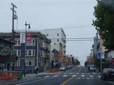 San Francisco, California - Temmuz 2018: Her iki taraftaki park halindeki arabalar hariç neredeyse boş caddesi olan dükkanlar ve binalar. 