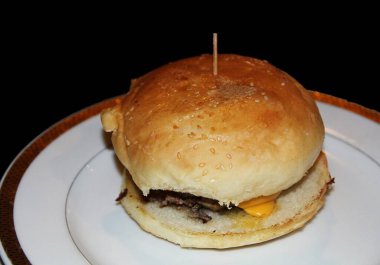 Bir çizburgerin orta yakın çekimi, siyah arkaplan 