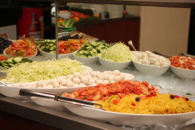Çeşitli taze kesilmiş sebzeler, haşlanmış yumurtalar, salata büfesinde servis edilen turşular..