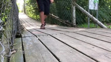 Tahta bir asma köprü, koşan bir adamla.
