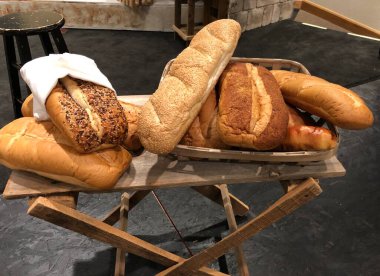 Derme çatma, ahşap bir masada sergilenen somunlar.