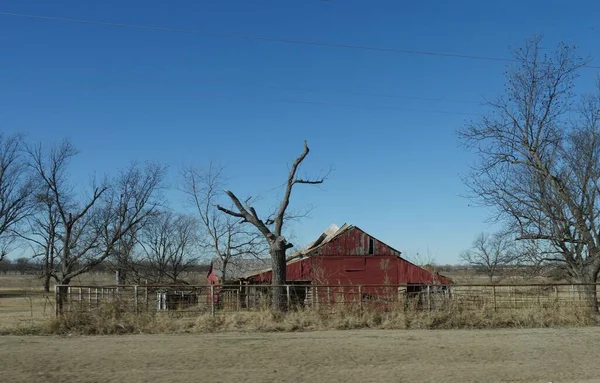 道路沿いの農地に放棄された赤い納屋 — ストック写真