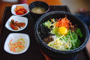 Bibimbap, ünlü bir Kore usulü sıcak pilav üstü aperatiflerle servis edilir..