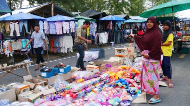 Narathiwat, Tayland - Mart 2016: Satıcılar Narathiwat 'ta bir sokak pazarında ayakkabı, sandalet ve giysi satıyorlar.  