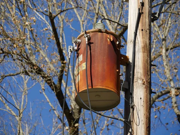 Rusty Transformator Een Power Pole Met Bladloze Bomen Achtergrond — Stockfoto