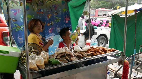 2016年3月 バンコクの屋台で魚のフライを売っている女性と子供 — ストック写真