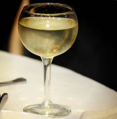 Beyaz şarapla dolu dairesel cam.