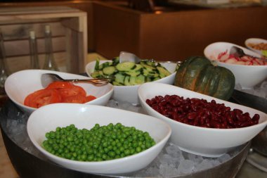 Büfe restoranındaki salata barında çeşitli fasulyeler ve taze sebzeler.