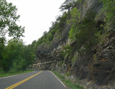Oklahoma 'daki Ozard Dağları eteklerinde katı bir kaya duvarı olan manzaralı bir yol.