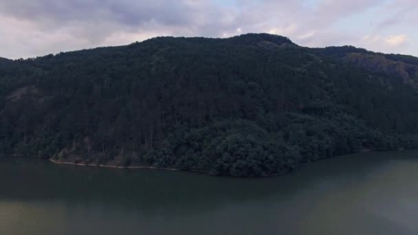 Belle vue aérienne d'un lac entre collines verdoyantes au coucher du soleil — Video