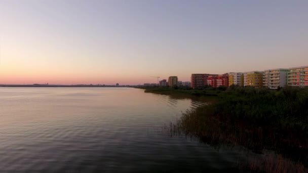 Günbatımında sakin sahile bakan deniz manzaralı renkli binaların güzel havadan görünümü — Stok video