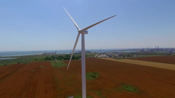 Aerial view of a white wind turbine by the sea with a view of the water — Stock Video