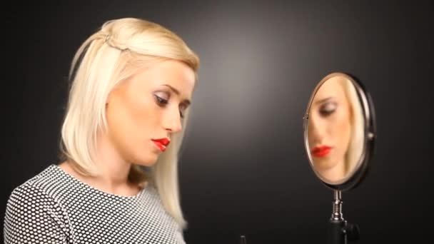 Blondes Mädchen, das im Spiegel errötet — Stockvideo