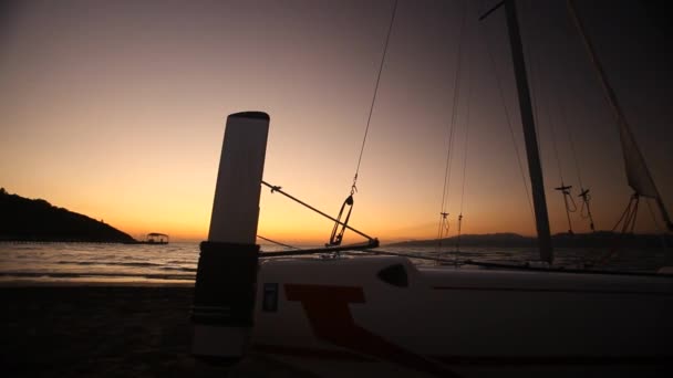 Bateau et plage au coucher du soleil. Mouvement de panoramique — Video