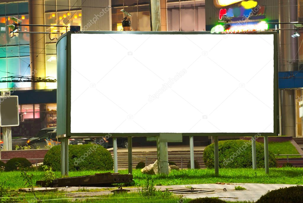 Blank signboard on the background of the night city. Mockup for design. Free space for advertising.
