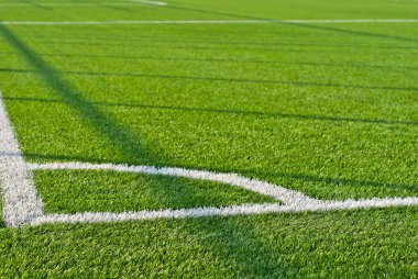 Futbol sahası dokusu yakın. Stadyumda ot var. Spor sahaları için iyi biçilmiş çimenler. Düz çizgiler beyaz boyayla çizilir. Stadyumdaki kısıtlı bölgeler.