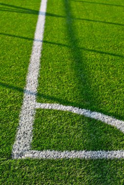 Futbol sahası dokusu yakın. Stadyumda ot var. Spor sahaları için iyi biçilmiş çimenler. Düz çizgiler beyaz boyayla çizilir. Stadyumdaki kısıtlı bölgeler.