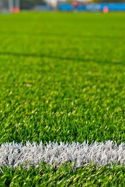 Futbol sahası dokusu yakın. Stadyumda ot var. Spor sahaları için iyi biçilmiş çimenler. Düz çizgiler beyaz boyayla çizilir. Stadyumdaki kısıtlı bölgeler.