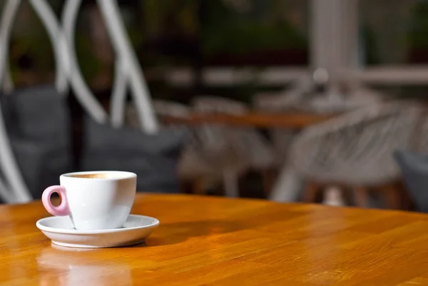 木製の板の上に白いコーヒーカップ 黒のバーのインテリアを背景に コーヒーの近くのフリースペース — ストック写真